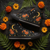 Calendula High Tops — folk-art orange marigolds, golden daisies, and a crescent moon on black — flat lay with candle and dried roses