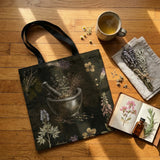 Belladonna Tote Bag on wood floor with herbal tea, dried lavender, and herbarium journal