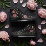 Paeonia High Tops — embroidered blush-pink peonies with a golden crescent moon on black — flat lay with candle and dried roses