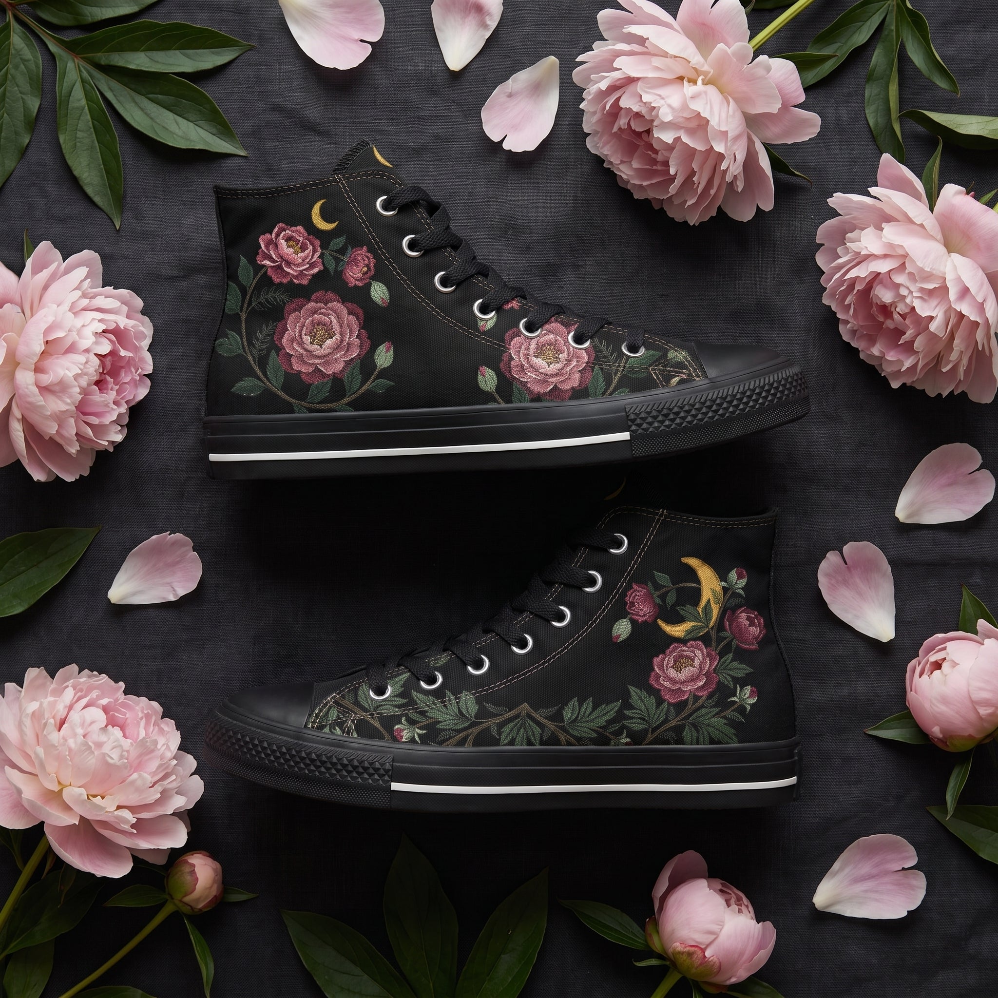 Paeonia High Tops — embroidered blush-pink peonies with a golden crescent moon on black — flat lay with candle and dried roses